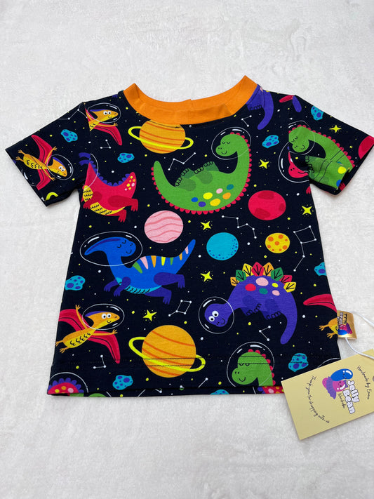 Colorful space-themed fabric with planets and stars and dinosaurs on a black background